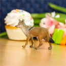 Lifelike 3.75-inch Coyote figurine by Safari Ltd. positioned on a table with a backdrop of colorful cupcakes and decorations.
