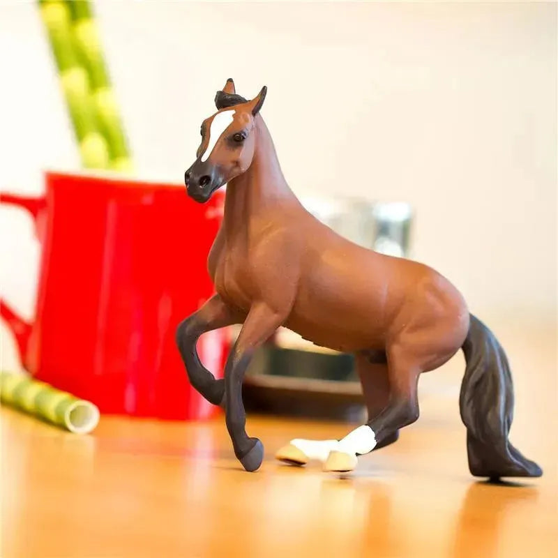 Thoroughbred horse figurine with detailed features, standing on a table with a red mug and green straws in the background.
