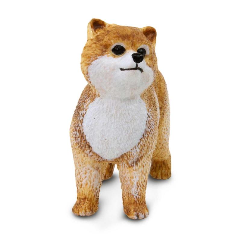 Realistic Pomeranian figurine with a fluffy golden coat and white chest, standing in a playful pose.