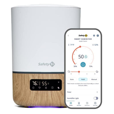 Smart humidifier by Safety 1st with a white upper and wood base, shown with a connected smartphone app displaying settings.