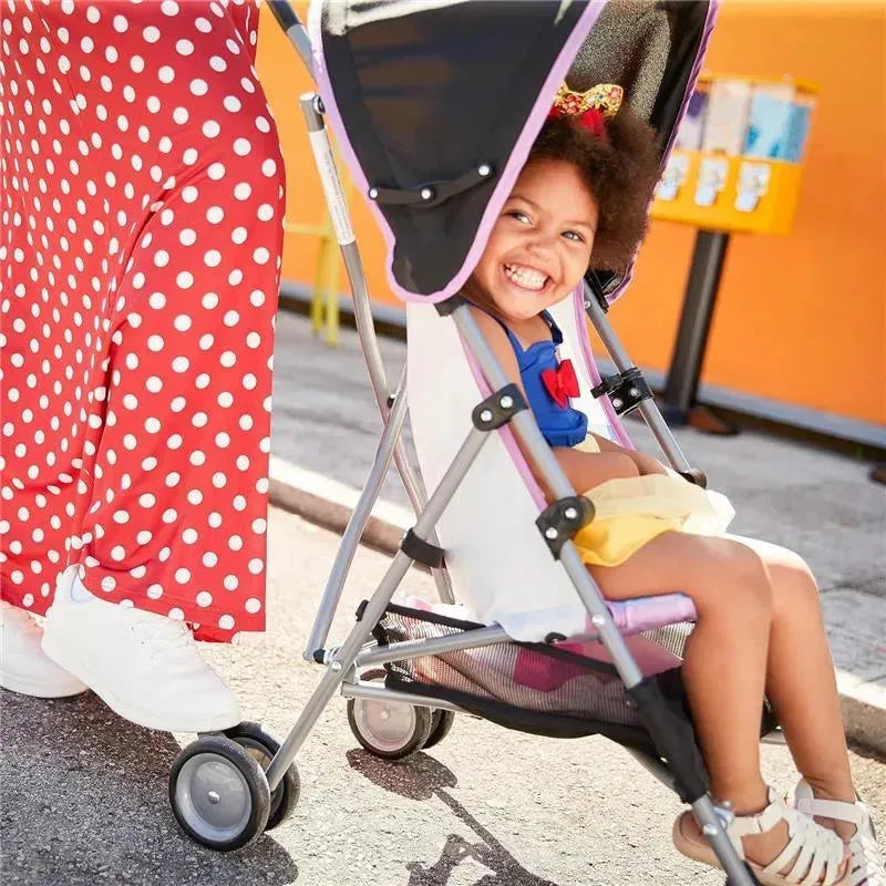 Minnie-themed umbrella stroller with a smiling young girl seated, wearing a blue top and yellow skirt, against a colorful background.