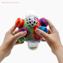 Colorful, textured developmental ball with a smiling face held by two hands, featuring small beads inside a clear bottom.