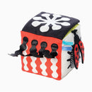 Colorful soft fabric discovery cube with various textures, patterns, and attachments, including a ladybug motif.