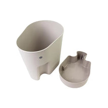Taupe Shnuggle bath toy storage scoop, featuring a main container and a smaller scoop with a playful design.