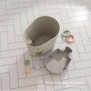 Taupe Shnuggle Ellie Bath Toy Storage Scoop with toys nearby; made from 98% recycled plastic.