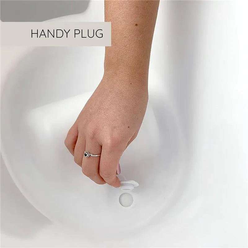 Hand reaching to remove the plug from a Shnuggle newborn baby bath, highlighting its handy plug feature.