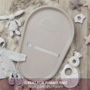 Squishy taupe baby changing pad with a soft, non-toxic PU foam surface, surrounded by baby clothes and toys.