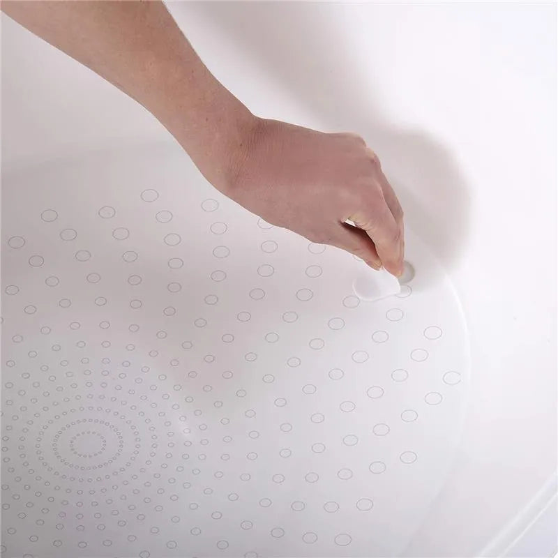 Hand applying suction cups to the textured surface of the Shnuggle Toddler Bath Tub in white and grey.