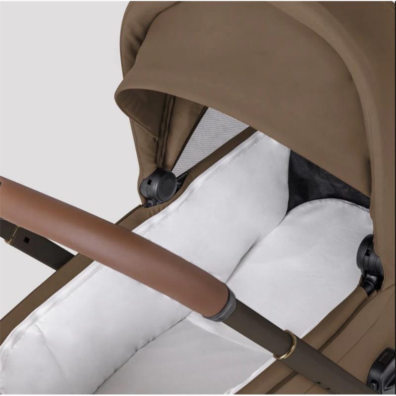 Modular stroller bassinet in Maple color, featuring a brown hood, white interior cushioning, and a sleek handlebar.