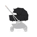 Compact folding bassinet in Onyx Black, featuring a sleek design and adjustable canopy, mounted on a lightweight stroller frame.