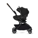 Compact travel stroller and bassinet bundle in Conifer color, featuring a sleek design, adjustable canopy, and storage basket.