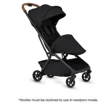 Silver Cross Nia compact stroller and bassinet bundle in black with a brown handle, suitable for newborn use.