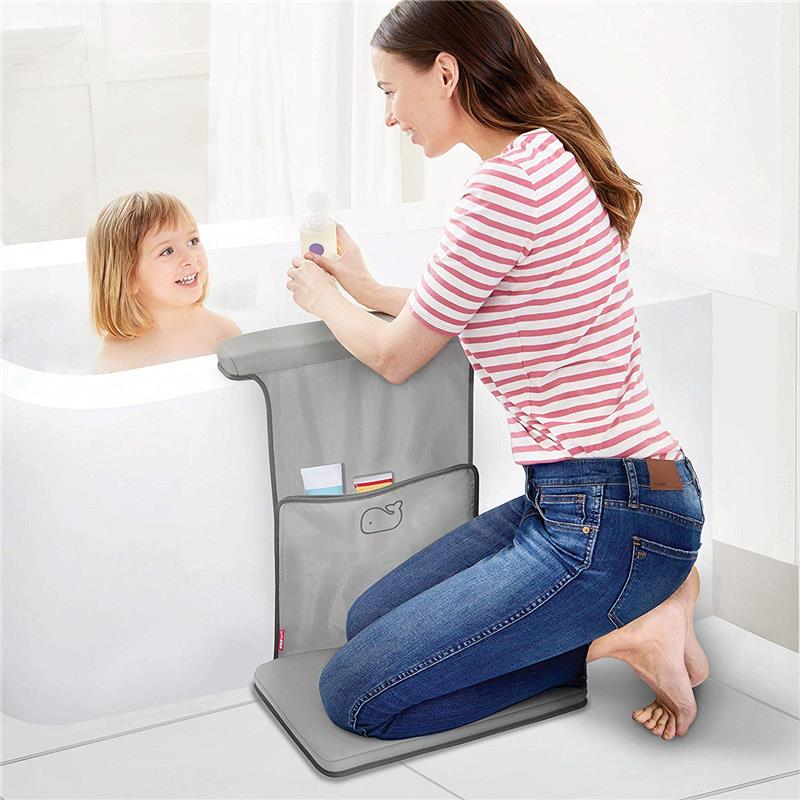 Mother kneeling on a grey Skip Hop Baby Bath Moby Elbow Saver & Kneeler, smiling at her child in the bath while holding a bottle.