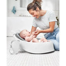 Mom interacts joyfully with her baby in the Skip Hop Moby Waterfall Baby Bath Rinser, a white bath accessory.