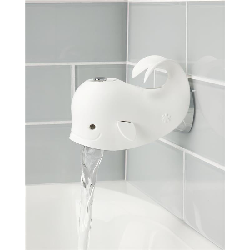 White whale-shaped spout cover, mounted on a tiled wall, with water flowing from its spout into a bathtub.