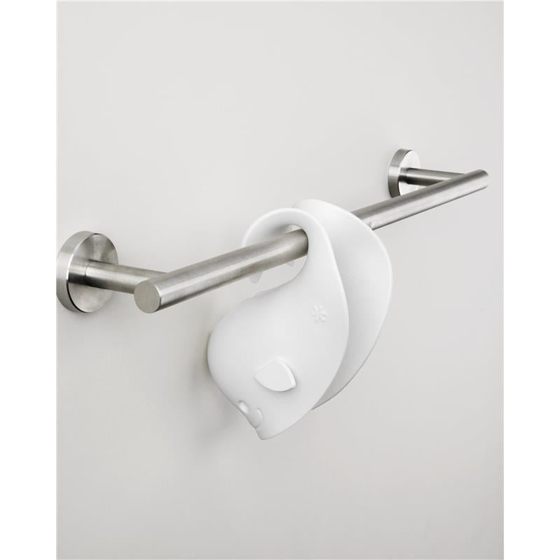 White Skip Hop Baby Bath Spout Cover with a playful design, hanging on a metal towel bar against a neutral wall.