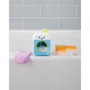 Baby bath toy featuring a smiling washing machine design, with bubbles, a purple washcloth, and an orange scoop.