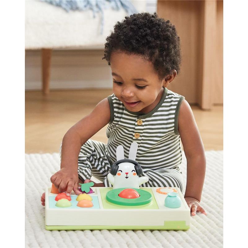 A toddler plays with the Skip Hop Baby Musical DJ Set Toy, featuring a rabbit character, colorful buttons, and lights.