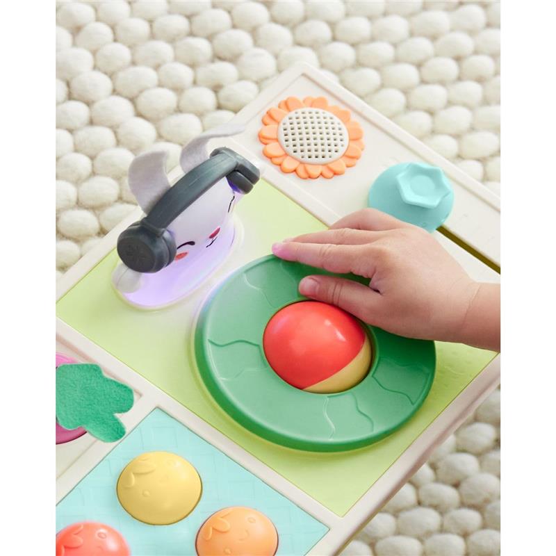 Baby’s hand interacts with the Skip Hop Baby Musical DJ Set Toy featuring colorful buttons, lights, and sound effects.