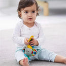 Toddler sitting on the floor, holding a yellow teether while playing with the Skip Hop Elephant toy featuring colorful patterns.