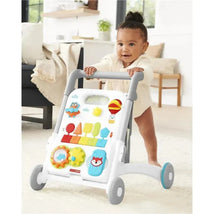 Toddler using the Skip Hop Grow Along 4-in-1 Activity Walker, featuring colorful buttons and toys for interactive play.
