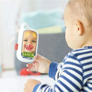 Baby holding a Skip Hop Explore & More Selfie Cellphone Toy featuring a mirror reflecting playful designs and facial features.