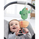 Cactus-shaped plush hanging toy from Skip Hop, attached to a stroller, with a joyful baby reaching for it.