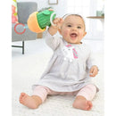 Baby wearing a grey striped dress with a unicorn graphic joyfully holds a Skip Hop Cactus Jitter Hanging Toy.