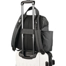 Black Skip Hop Forma Next Backpack secured on a wheeled suitcase, featuring adjustable straps and side pocket.