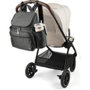 Skip Hop Forma Next Backpack in black attached to a stroller, features multiple compartments and a side pocket for a drink.