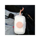 Blush Skip Hop Grab & Go Snug Seal Wipes Case attached to a bag, featuring a soft pink latch and round button.