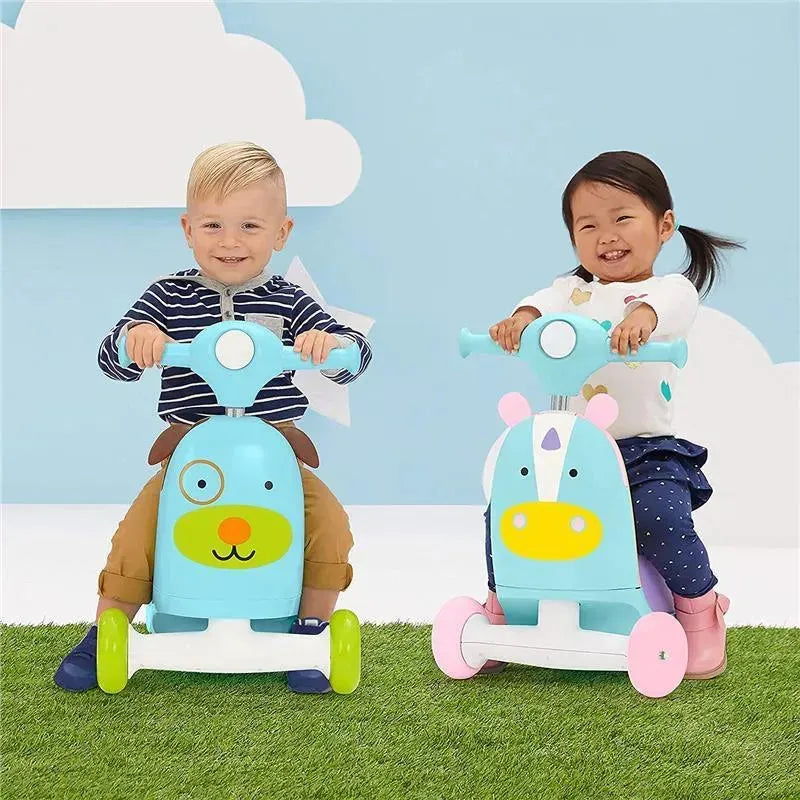 Two children ride colorful Skip Hop Zoo 3-In-1 Ride-On Toys, one designed as a dog and the other as a unicorn, smiling against a soft blue backdrop.