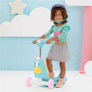 Child riding a blue and pink Skip Hop Zoo 3-In-1 Ride-On Toy designed as a unicorn, wearing a helmet, and smiling.