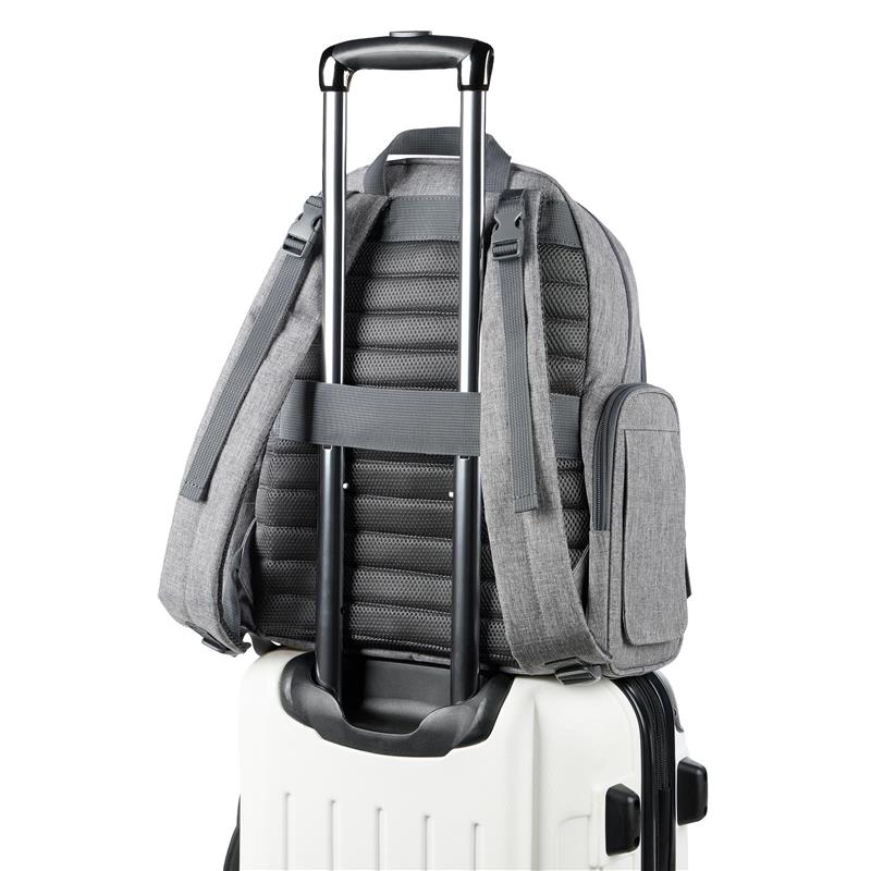 Heather grey Skip Hop Luna Diaper Bag Backpack positioned on a white suitcase, showcasing its adjustable straps and side pocket.