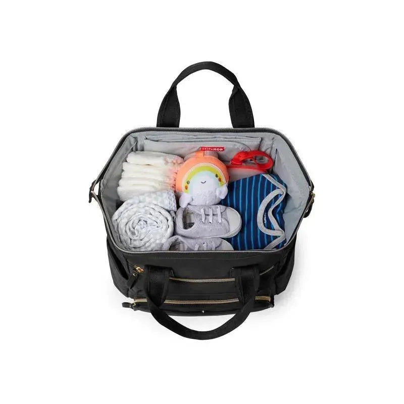 Black Skip Hop Mainframe Wide Open Diaper Backpack opened to show neatly packed baby essentials including diapers, a toy, and clothes.