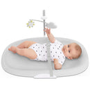 Wipe-clean changing pad in grey featuring a baby in a white onesie reaching for a hanging toy with a sun and cloud.