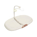 Skip Hop Nursery Style Wipe-Clean Changing Pad in Oat color, featuring a safety strap and a mobile with sun and cloud.