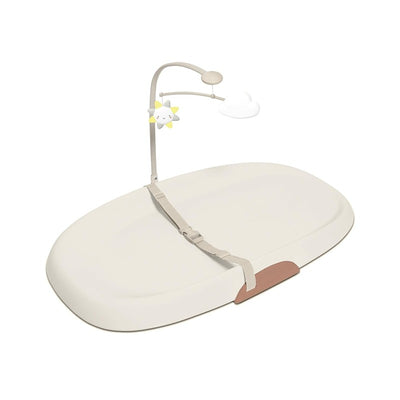 Skip Hop Nursery Style Wipe-Clean Changing Pad in Oat color, featuring a safety strap and a mobile with sun and cloud.