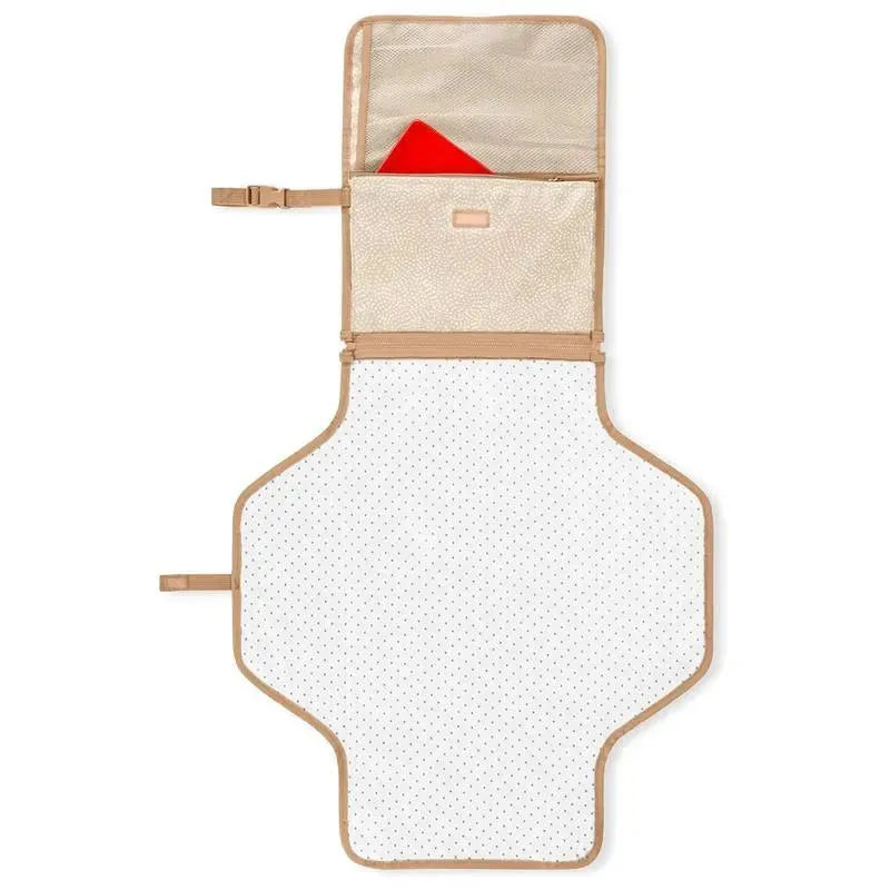 Portable baby changing pad in beige swirl dot pattern, featuring a large white changing area with polka dots and a storage pocket with a red item inside.