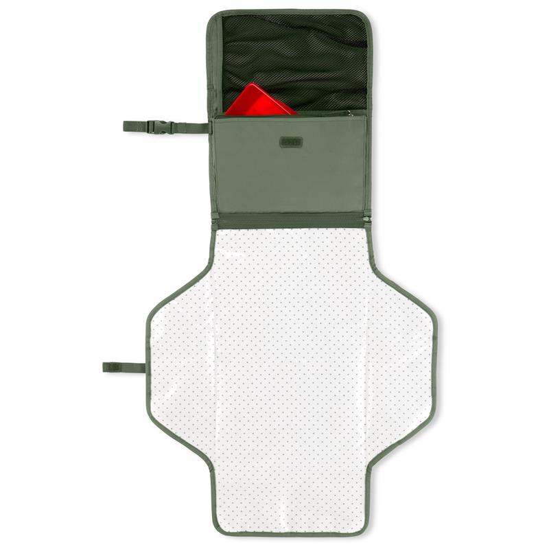 Portable baby changing pad in sage green with a white polka dot surface and storage pocket containing a red item.