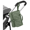 Portable baby changing pad in sage green attached to a stroller handle, featuring a zippered pocket and secure strap.