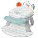 2-in-1 activity floor seat with a plush cloud pattern, safety harness, and toy attachments featuring a sun, moon, and star.