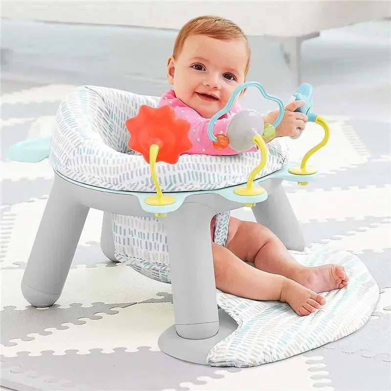 A baby sits in a Skip Hop Silver Lining Cloud 2-in-1 Activity Floor Seat with engaging toys, smiling happily.