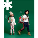 Two kids showcasing the Skip Hop Spark Style Big Kid Backpack, one wearing a smaller version in red and the other a larger one in green.