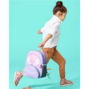 Little girl with a seashell-themed Skip Hop backpack, walking against a bright turquoise background.