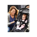 A mother smiles at her baby in a stroller, which features a Skip Hop portable sound machine shaped like an owl.