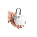 Portable baby sound machine in the shape of an owl, held in a hand, featuring buttons and a strap for easy attachment.