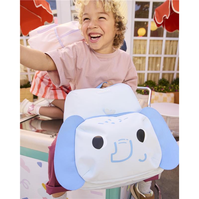 Toddler happily holding a blue elephant-themed backpack with adjustable padded straps, showcasing its playful design.