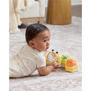 Baby playing on a rug with the Skip Hop Tummy Time & Seated Play toy featuring a smiling face, bee handle, and colorful elements.
