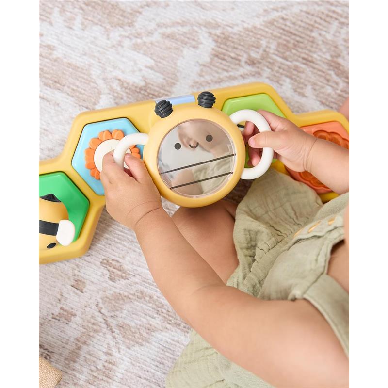 Baby playing with the Skip Hop Tummy Time & Seated Play toy, featuring a bee shape with a mirror and colorful buttons.